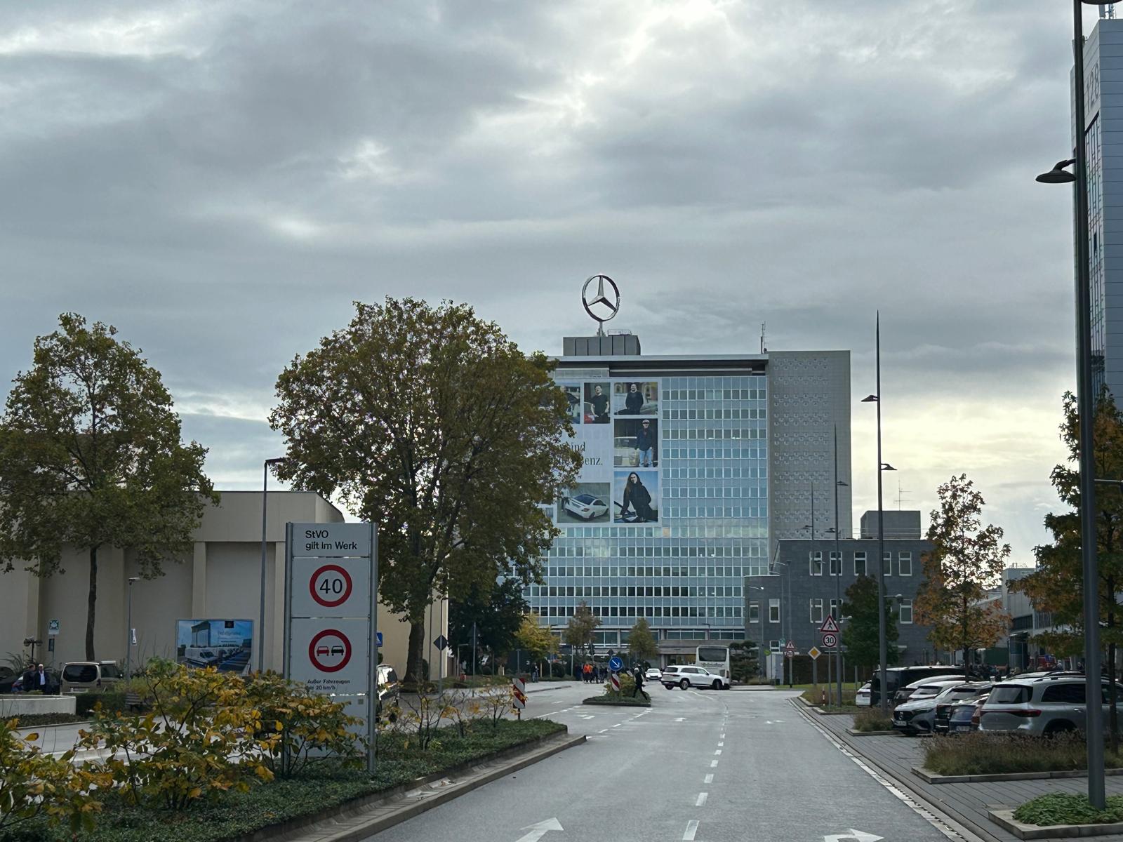 Blick auf ein großes graues Bürogebäude mit Mercedes-Stern und vielen Fenstern