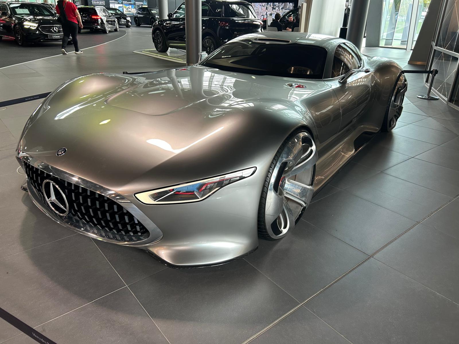 Ein futuristischer silbergrauer Mercedes Sportwagen mit markantem Kühlergrill steht ausgestellt
