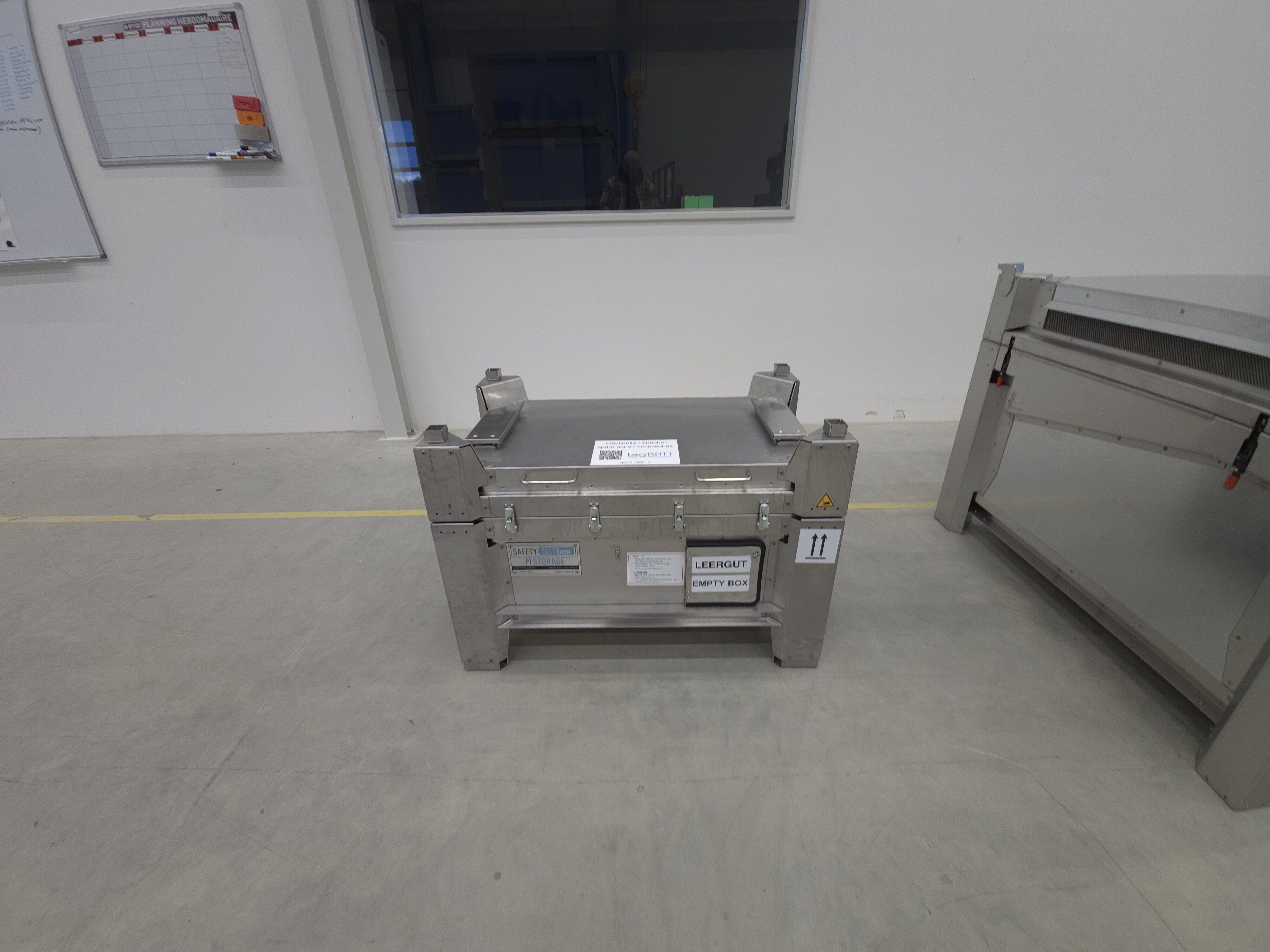 M-Storage mit Warnsymbol und Etiketten auf Betonboden im Raum