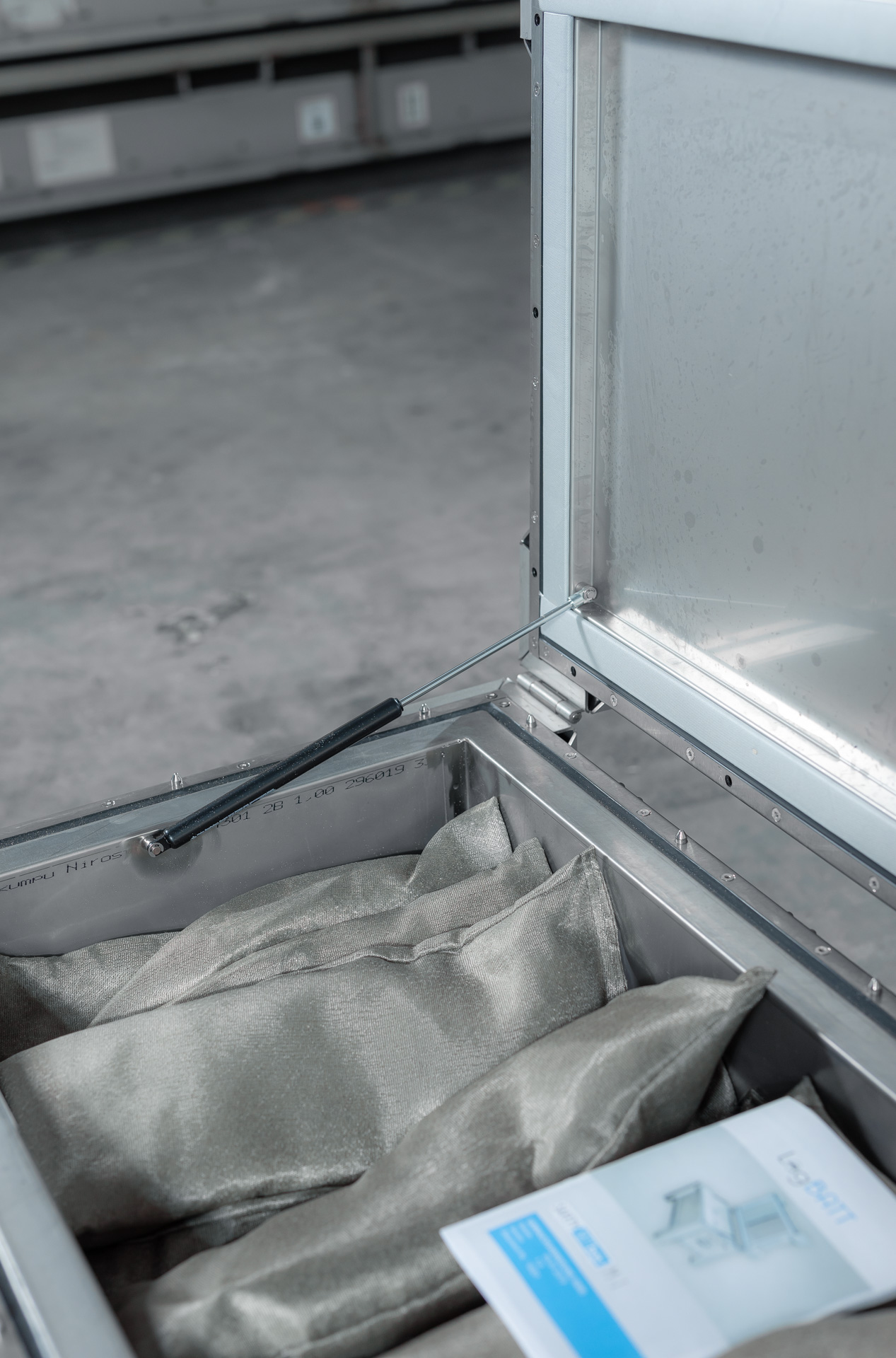 Offene SafetyBATTbox M-2 mit Stoffbeutel und blauem Faltblatt